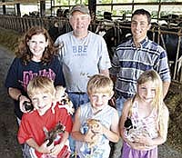The Heieie family milks 120 cows near Brooten, Minn. They are pictured, front row, from left, Max (7), Gunner (7) and Annika (9). Back row, from left, Sara, Todd and employee, Delmar Wengar. The Heieies’ herd average last year was 30,237 pounds of milk.<br /><!-- 1upcrlf -->PHOTO BY MISSY MUSSMAN