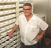 Keith Adams stands next to cheese in a refrigerator at his business, Alemar Cheese Company in Mankato, Minn. Adams, owner and cheesemaker, received a Value Added grant as part of the Agricultural Growth, Research and Innovation Program through the Minnesota Department of Agriculture. <br /><!-- 1upcrlf -->PHOTO BY KRISTA KUZMA