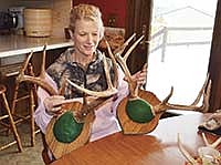 Mary Schornack looks at two set of antlers from bucks she shot in previous years. This year marks Schornack’s 19th year deer hunting. <br /><!-- 1upcrlf -->PHOTO BY MISSY MUSSMAN