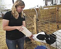 Warren feeds a calf on her family’s farm near Litchfield, Minn. The Warrens milk 140 cows.<br /><!-- 1upcrlf -->PHOTO BY ANDREA BORGERDING