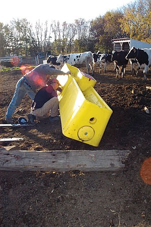 On the Henry farmsite, Roger and son, Darrell, install a temporary waterer for heifers. (photo by Krista M. Sheehan)
