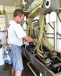 Wenninger cleans one of his milking units after a milking. <br /><!-- 1upcrlf -->PHOTO BY RUTH KLOSSNER